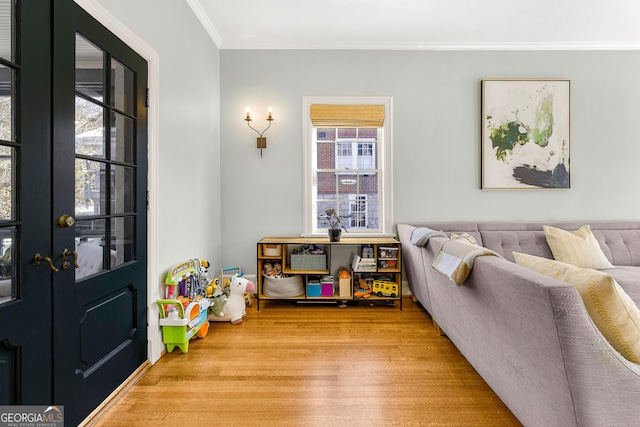 living room with french doors, light hardwood / wood-style flooring, and crown molding