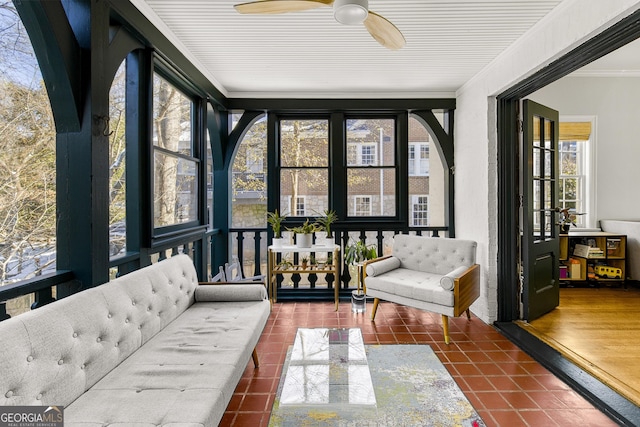 sunroom featuring ceiling fan and plenty of natural light