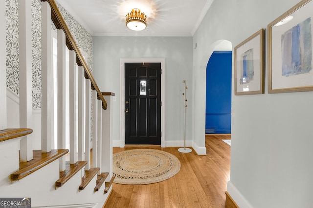 foyer entrance with wood-type flooring and ornamental molding