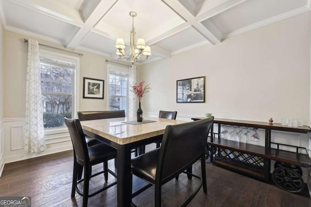 dining area featuring a chandelier, dark wood-type flooring, coffered ceiling, and ornamental molding