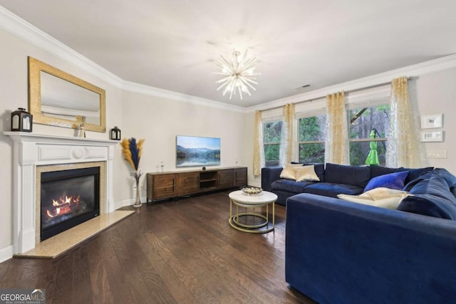 living room featuring a high end fireplace, dark hardwood / wood-style flooring, crown molding, and a notable chandelier