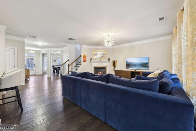 living room with ornamental molding, dark wood-type flooring, and a chandelier