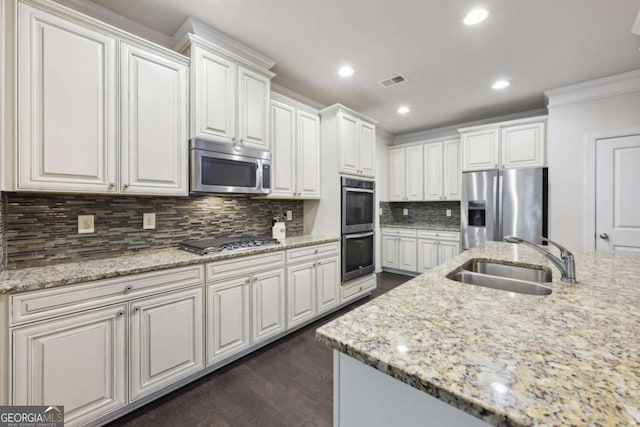 kitchen featuring light stone counters, sink, white cabinets, and stainless steel appliances