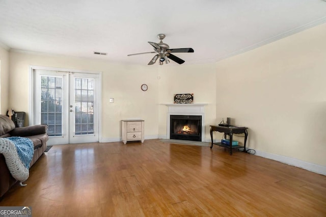 living room with crown molding, ceiling fan, and wood-type flooring