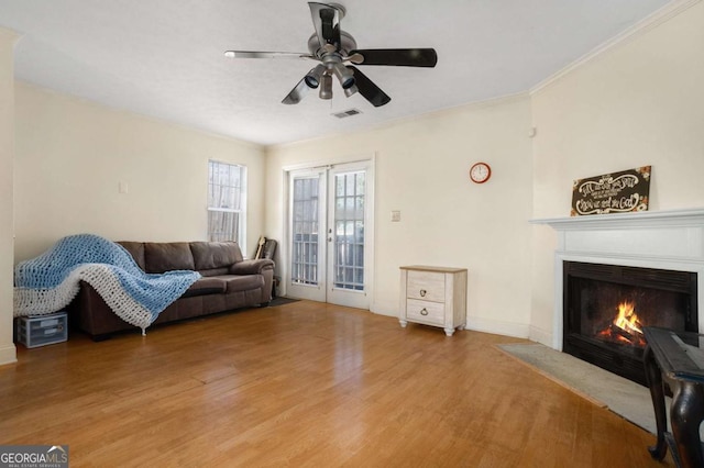 living room featuring hardwood / wood-style floors, ceiling fan, and ornamental molding