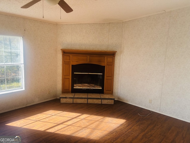 unfurnished living room featuring a textured ceiling, hardwood / wood-style flooring, ceiling fan, and crown molding