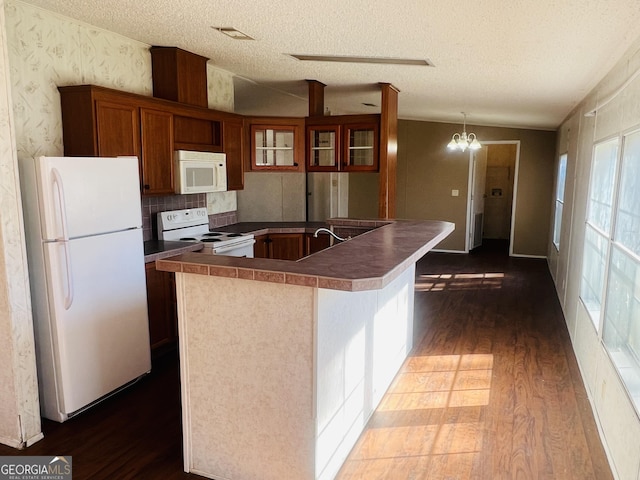 kitchen featuring a textured ceiling, white appliances, an inviting chandelier, and dark wood-type flooring