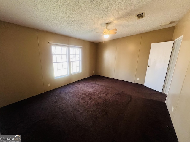 carpeted spare room with ceiling fan and a textured ceiling