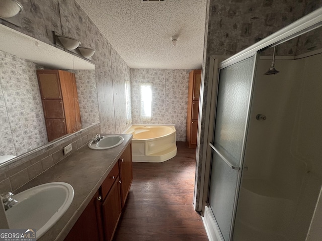 bathroom with separate shower and tub, hardwood / wood-style floors, a textured ceiling, decorative backsplash, and vanity