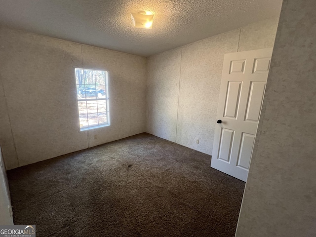 carpeted spare room with a textured ceiling