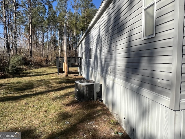 view of property exterior with central AC, a yard, and a deck