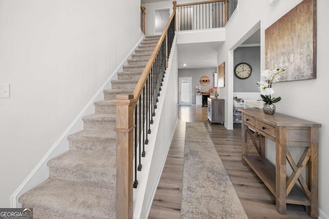 foyer with a towering ceiling and hardwood / wood-style flooring