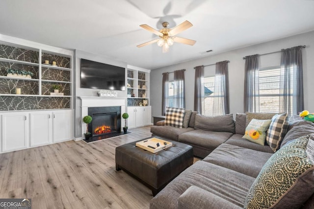 living room with a wealth of natural light, ceiling fan, and light hardwood / wood-style floors