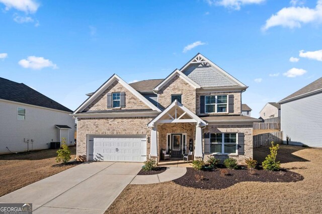 view of front of home with a porch, central AC unit, and a garage