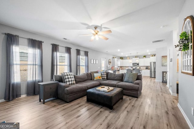 living room featuring light wood-type flooring and ceiling fan