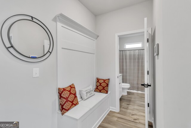 full bathroom with curtained shower, toilet, and wood finished floors