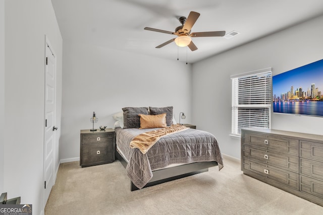 carpeted bedroom with visible vents, baseboards, and a ceiling fan