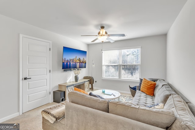 living area featuring baseboards, a ceiling fan, and carpet