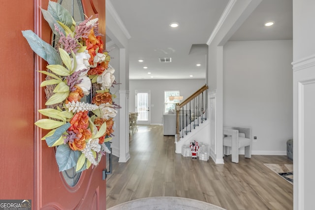 entrance foyer with crown molding and light hardwood / wood-style flooring