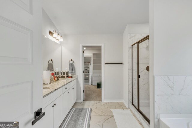 full bath featuring vanity, a stall shower, a walk in closet, a bath, and marble finish floor