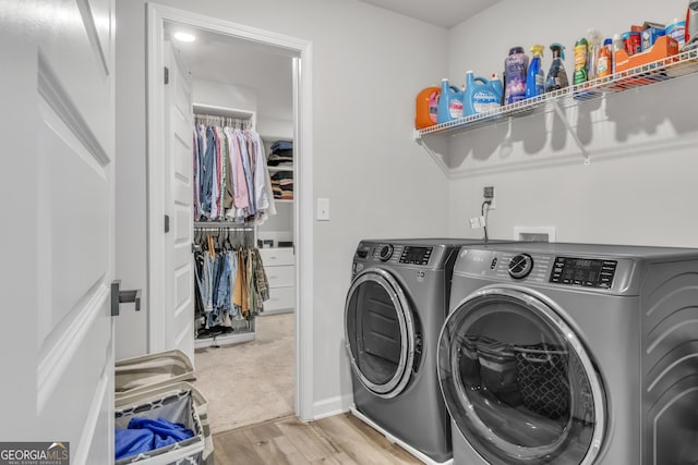 laundry room featuring laundry area, wood finished floors, and washing machine and dryer