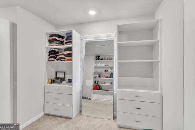 spacious closet featuring light colored carpet and visible vents