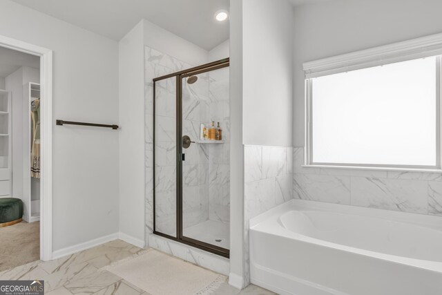 full bathroom featuring baseboards, a marble finish shower, a walk in closet, a bath, and marble finish floor