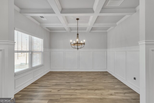 unfurnished dining area featuring light wood finished floors, visible vents, a decorative wall, beamed ceiling, and a notable chandelier