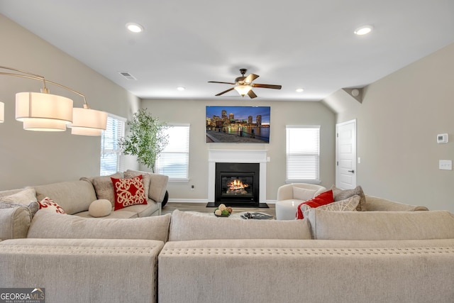 living room with visible vents, recessed lighting, ceiling fan, and a glass covered fireplace