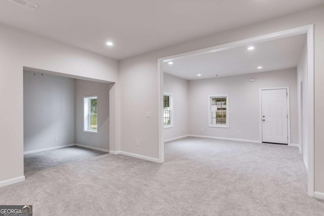 spare room featuring light carpet and a healthy amount of sunlight