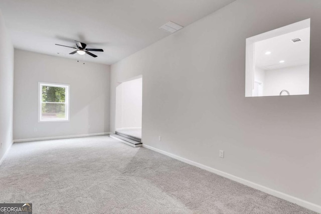 carpeted spare room with ceiling fan