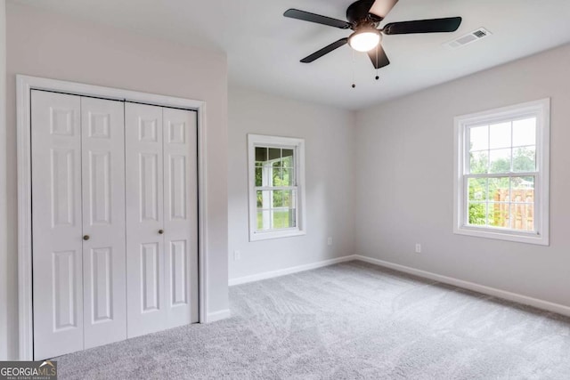 unfurnished bedroom with ceiling fan, carpet floors, and a closet