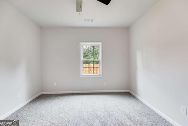 carpeted spare room with ceiling fan