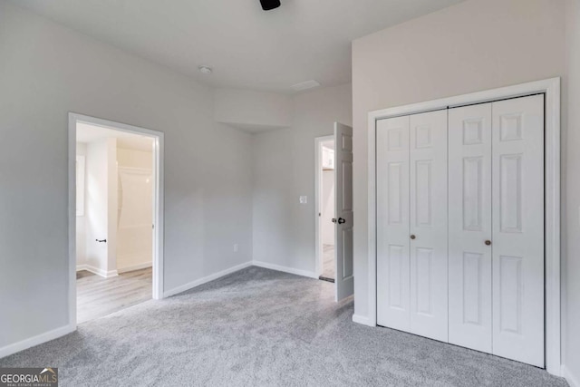 unfurnished bedroom with light carpet and a closet