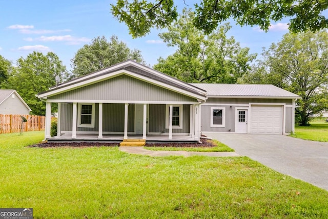 ranch-style home featuring covered porch, a front yard, and a garage