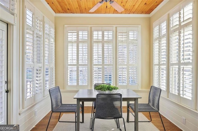 dining space featuring wood-type flooring, crown molding, wooden ceiling, and ceiling fan