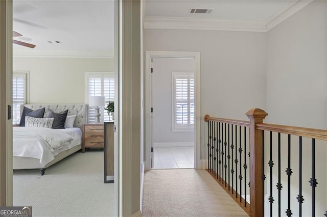 carpeted bedroom featuring ornamental molding, ceiling fan, and ensuite bath