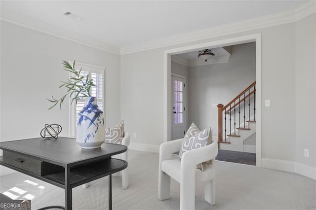 living area with ornamental molding and carpet flooring