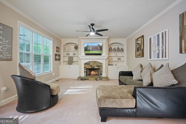 carpeted living room with a stone fireplace, ceiling fan, built in features, and ornamental molding