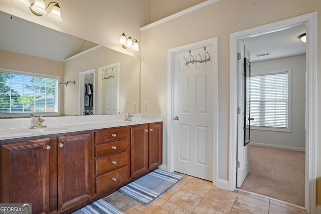 bathroom with tile patterned floors, plenty of natural light, vanity, and vaulted ceiling