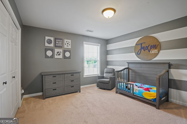 carpeted bedroom with a closet and a nursery area