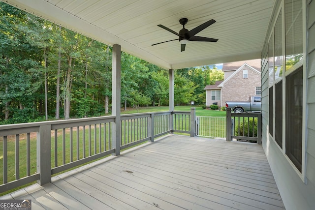 wooden terrace with a lawn and ceiling fan