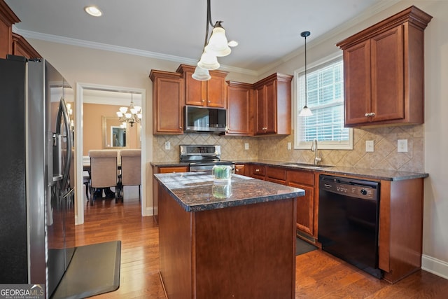 kitchen featuring sink, hanging light fixtures, stainless steel appliances, a chandelier, and a kitchen island