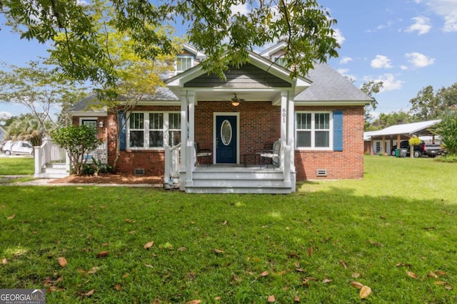 view of front facade with a front yard, brick siding, roof with shingles, and crawl space