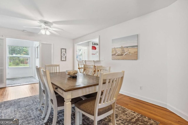 dining area with ceiling fan, baseboards, and wood finished floors