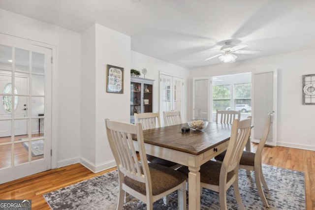 dining room with baseboards, light wood-style flooring, and a ceiling fan