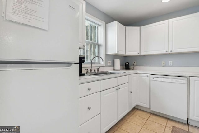 kitchen with white appliances, white cabinetry, light countertops, and a sink