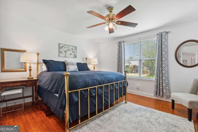 bedroom with ceiling fan, baseboards, and wood finished floors