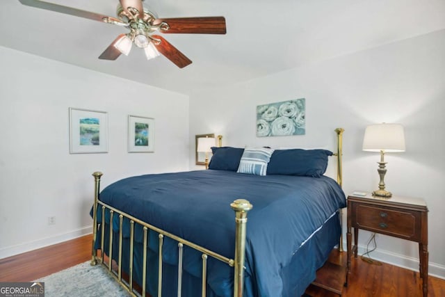 bedroom with a ceiling fan, wood finished floors, and baseboards