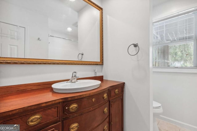 bathroom with tile patterned floors, toilet, vanity, and baseboards